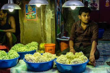 Chennai, Tamil Nadu, Hindistan - Ağustos 2018: Georgetown çiçek pazarında çiçek satan genç Hintli bir adamın portresi.