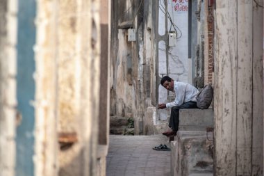 Somnath, Gujarat, Hindistan - Aralık 2018: Yol kenarında oturan Hintli bir adam.
