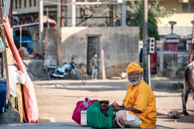 Somnath, Gujarat, Hindistan - Aralık 2018: Kutsal şehrin sokaklarında safran sarığı takan yaşlı bir Hintli keşişin portresi.