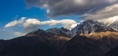 Hindistan 'ın Kinnaur kentindeki Kalpa köyünün tepesinde süzülen bulutlarla Kinner Kailash Dağları' na vuran ince bir ışık hüzmesi..