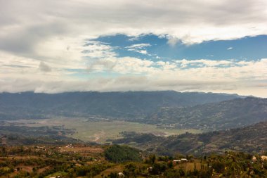 Nepal 'in Tansen kasabası çevresinde dramatik bir gökyüzü ve yeşil tepelerle pitoresk Madi Vadisi' nin engin manzarası.