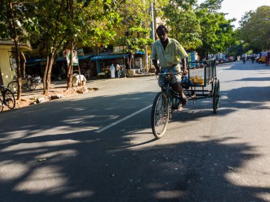 Pondicherry, Hindistan - Şubat 2020: Pondicherry sokaklarında tekerlekli bir arabaya binen Hintli bir işçi.