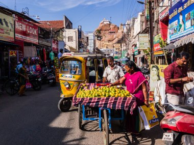 Trichy, Tamil Nadu, Hindistan - Şubat 2020: Eski Rock Fort Tapınağı 'na giden kaotik sokakta meyve satan bir sokak satıcısı.
