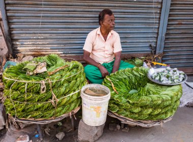 Trichy, Tamil Nadu, Hindistan - Şubat 2020: Yaşlı bir Hintli kadın Tiruchirappalli pazarında yol kenarında parlak metal bobinler ve lambalar satıyor.