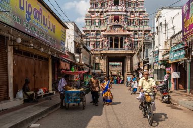 Trichy, Tamil Nadu, Hindistan - Şubat 2020: Srirangam 'daki antik Ranganathaswamy tapınağı etrafındaki pazar caddelerinde bisiklet süren bir adam.