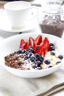 Granola kahvaltı çilek, yaban mersini, ahşap arka plan üzerinde fıstık ile
