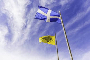 Hava bulutlu gökyüzü karşı sallayarak Yunan ve Bizans bayrakları