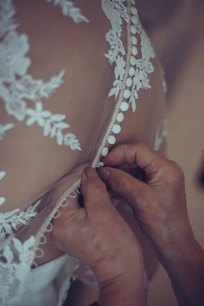 Dama de honra preparando noiva para o dia do casamento. A dama de honra ajuda a fixar um vestido de casamento a noiva antes da cerimônia. Vestido de noiva de luxo perto. Melhor manhã de casamento . — Fotografia de Stock