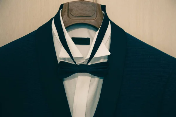 O terno preto elegante com camisa branca e gravata borboleta no cabide. preparações da manhã antes do dia do casamento. roupa de noivo — Fotografia de Stock