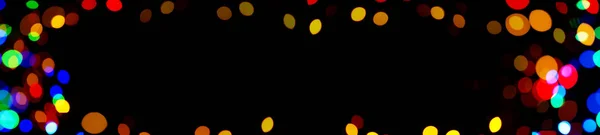 Defocused photographic image of Christmas lights with a free field for text. Panoramic format for banner.