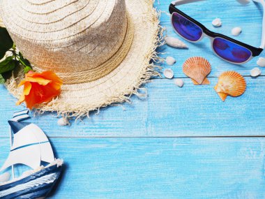 Tatil tatil arka plan. Üstten görünüm hasır şapka, güneş gözlüğü, kabukları ve Çince kopya alanı ile mavi ahşap üzerine çiçek gül. 