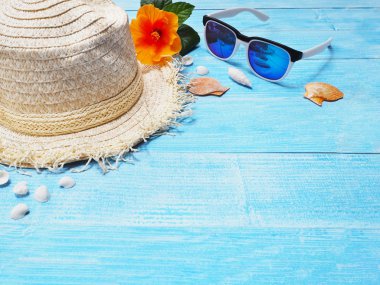 Tatil tatil arka plan. Üstten görünüm hasır şapka, güneş gözlüğü, kabukları ve Çince kopya alanı ile mavi ahşap üzerine çiçek gül. 