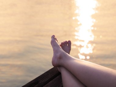 Selfie gün batımı yaz sahilde ahşap arka plan üzerinde çıplak ayak. Gevşeme tatil kavramı.