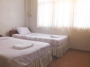 İki tek kişilik yatak ile güneş ışığı ucuz otel, pencereden genel yatak odası iç.