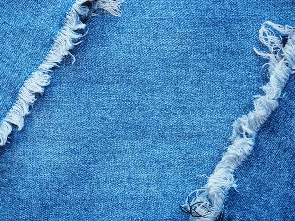 Edge frame of blue denim ripped destroyed torn over jeans texture background.