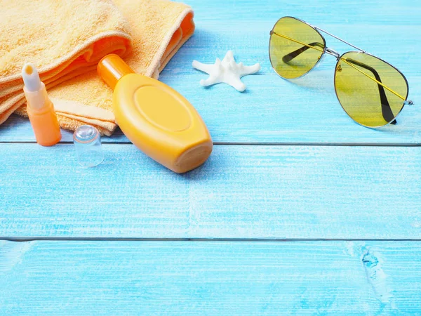 Üstten Görünüm güneşlenmek aksesuarları veya kopya alanı ile mavi ahşap arka plan ayarlamak güneş kremi. Yaz tatil tatil kavramı.