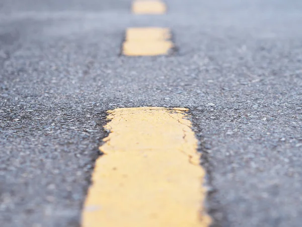 Perspektywa żółta linia na asfaltowej powierzchni ulicy. — Zdjęcie stockowe