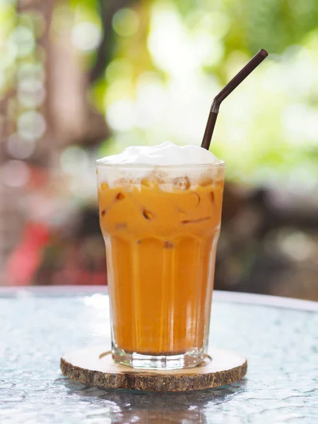 Verre de thé au lait thaïlandais avec crème fouettée sur le dessus et paille à c — Photo