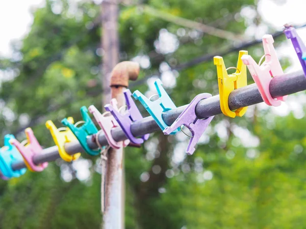 Kolorowe plastikowe clothespin wiszące na metalowym pasku — Zdjęcie stockowe