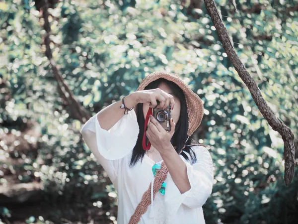 Mujer sosteniendo la cámara de fotografía de rodaje en el verano verde para —  Fotos de Stock