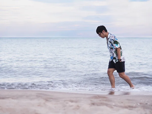 Asiatique homme marchant seul sur le sable le long de la plage le matin . — Photo