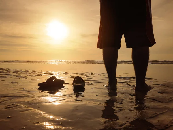 Silhouette vue arrière du jeune homme debout au coucher de soleil doré beac — Photo