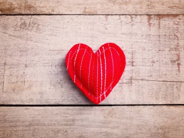Vintage ahşap masa üzerinde Yastık el sanatları kırmızı kalp şekli.