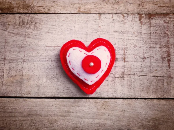Kussen handwerk rood hart vorm op Vintage houten tafel. — Stockfoto