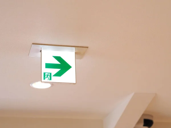 Illuminated exit sign hanging from the ceiling