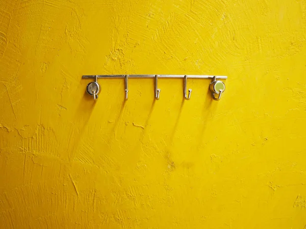 Metalowy stojak na żółtą ścianę cementową grunge — Zdjęcie stockowe