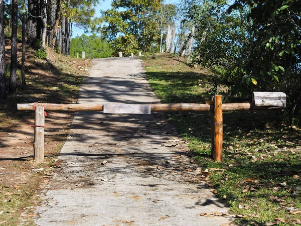 Wooden vintage barrier at the entrance on the forest road.