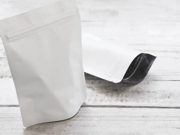 White zipper bag for food packaging. Empty zip package on vintage wooden table.