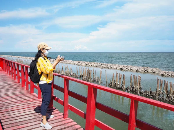 Turista Asiática Con Máscara Facial Parada Puente Rojo Tomando Fotografías — Foto de Stock