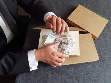 Masada Rus parası ve kitapları olan bir iş adamının elleri. 