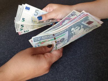 Kadınlar Avrupa banknotları ve Guatemala parası alışverişinde bulunuyor