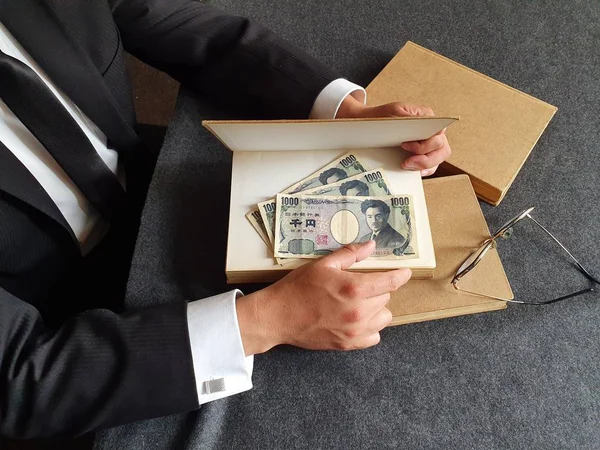 Händerna Affärsman Med Japanska Pengar Och Böcker Bordet — Stockfoto