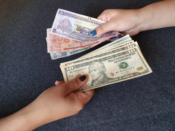 Frauenhände Tauschen Honduranische Banknoten Und Amerikanisches Dollargeld — Stockfoto