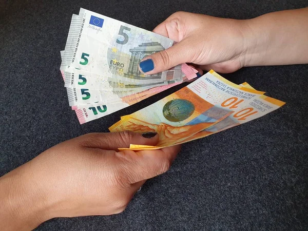 women hands exchanging European banknotes and Swiss money