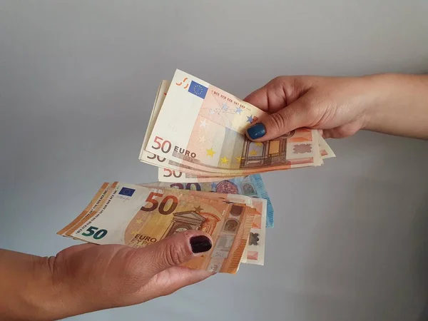 women hands paying and receiving European money
