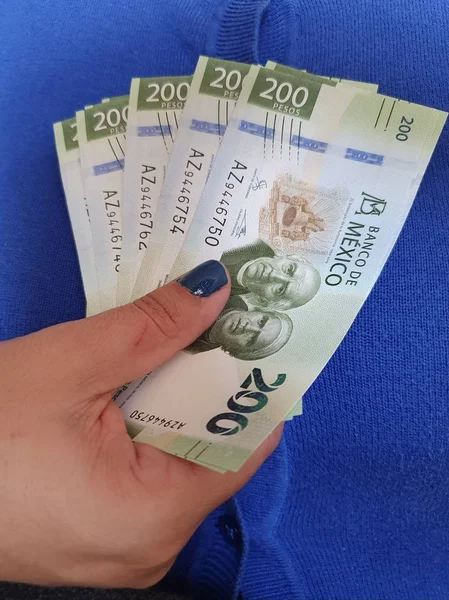 200 pezoluk Meksika banknotları tutan bir kadının eli.