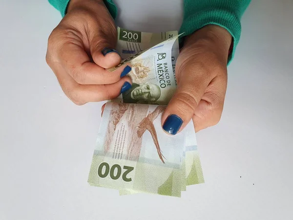 200 pezoluk Meksika banknotlarını sayan bir kadının elleri.