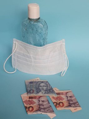 Hırvat banknotları, yüz maskesi, jel alkollü şişe ve mavi arka plan