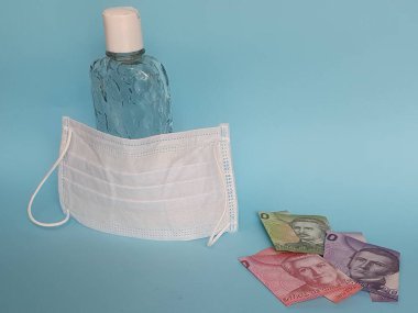 Şili banknotları, yüz maskesi, jel alkollü şişe ve mavi arka plan