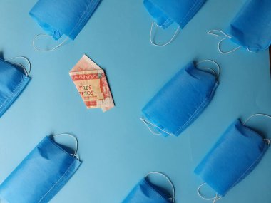 Mavi arka planda üç peso ve maskeli Küba banknotu