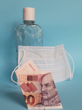 Hırvatistan 'ın yirmi kuna, yüz maskesi, jel alkollü şişe ve mavi arka planlı banknotu