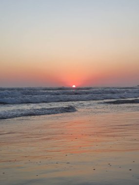 Günbatımında Meksika, Acapulco 'nun elmas bölgesindeki plaj dalgalarıyla tropikal bir manzara.