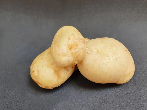 Drei Stücke Frisches Braunes Kartoffelgemüse Auf Der Schwarzen Oberfläche — Stockfoto