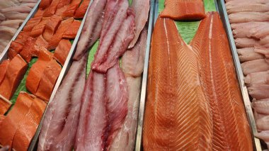 Taze balık filetosu ve bir süpermarkette konteynırlarda istiflenmiş deniz ürünleri.
