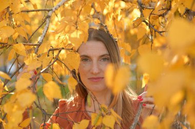Sarı yapraklı güzel bir genç kadının enfes portresi.