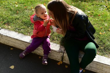 İfade dolu yüzü olan küçük güzel kız parkta pamuk şeker yiyor.